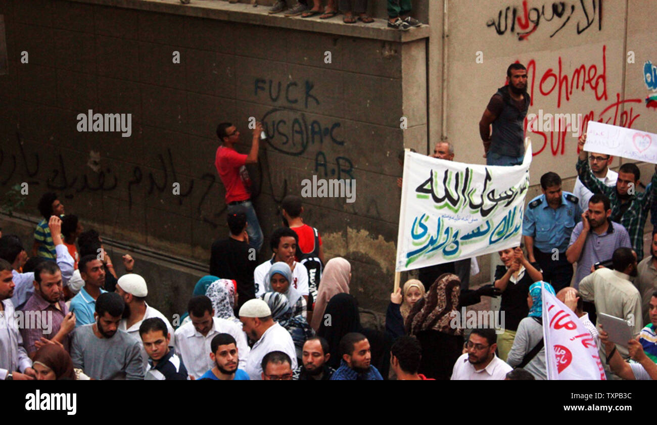 Egyptian protesters write anti-US slogans on the wall of the U.S. embassy  at the United States embassy in Cairo on September 11, 2012, during a demonstration against a film deemed offensive to Islam and the Prophet Mohammad.  In Libya, Islamic extremists killed the American ambassador as they stormed the American consulate in Benghazi in anger against the little known film by an amateur American filmmaker. Editors: Note Language   UPI/Ahmed Jomaa Stock Photo
