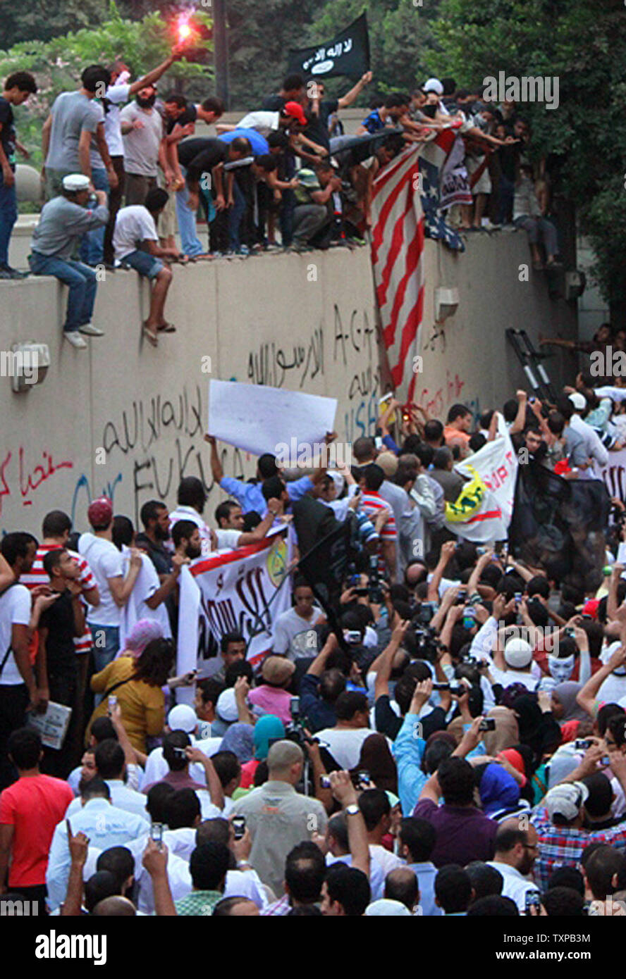 Egyptian protesters tear down an American flag at the United States embassy in Cairo on September 11, 2012, during a demonstration against a film deemed offensive to Islam and the Prophet Mohammad.  In Libya, Islamic extremists killed the American ambassador as they stormed the American consulate in Benghazi in anger against the little known film by an amateur American filmmaker.  UPI/Ahmed Jomaa Stock Photo