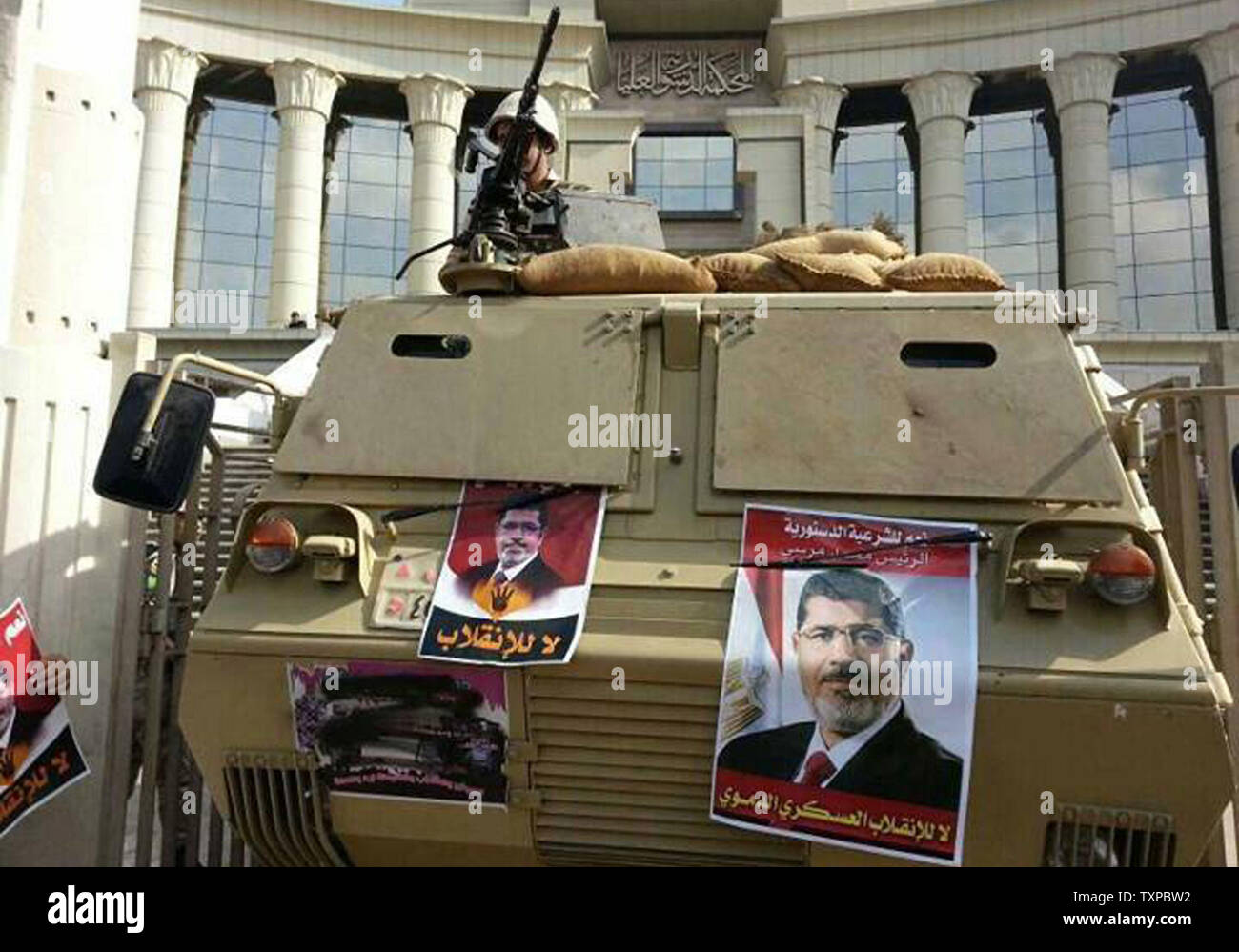 Posters of Egypt's ousted President Mohammed Morsi are seen on a tank outside of  his trial in Cairo, Egypt, November, 4, 2013. Egypt's deposed president Mohamed Morsi appeared in court Monday on the first day of his trial, rejecting its legitimacy and demanding 'coup' leaders be prosecuted, as thousands of his supporters rallied. UPI/Ahmed Jomaa Stock Photo