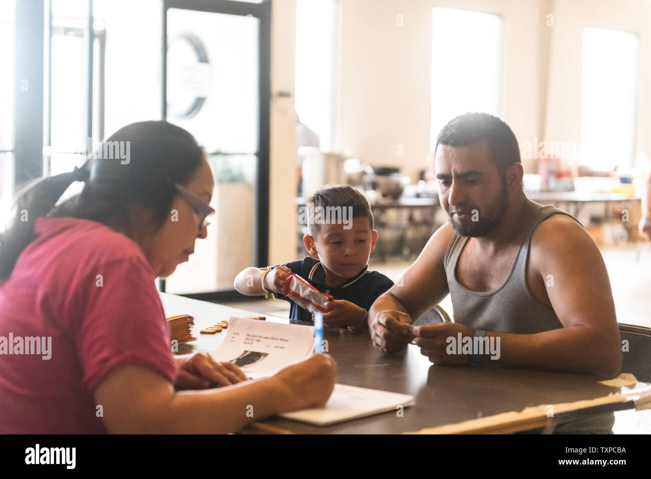 A volunteer helps a Guatemalan man and his son fill out the intake form for Camino de Vida in El Paso, Texas on March 22, 2019. Border Patrol detention centers have soared past capacity, prompting the mass release of migrants.     Photo by Justin Hamel/UPI Stock Photo