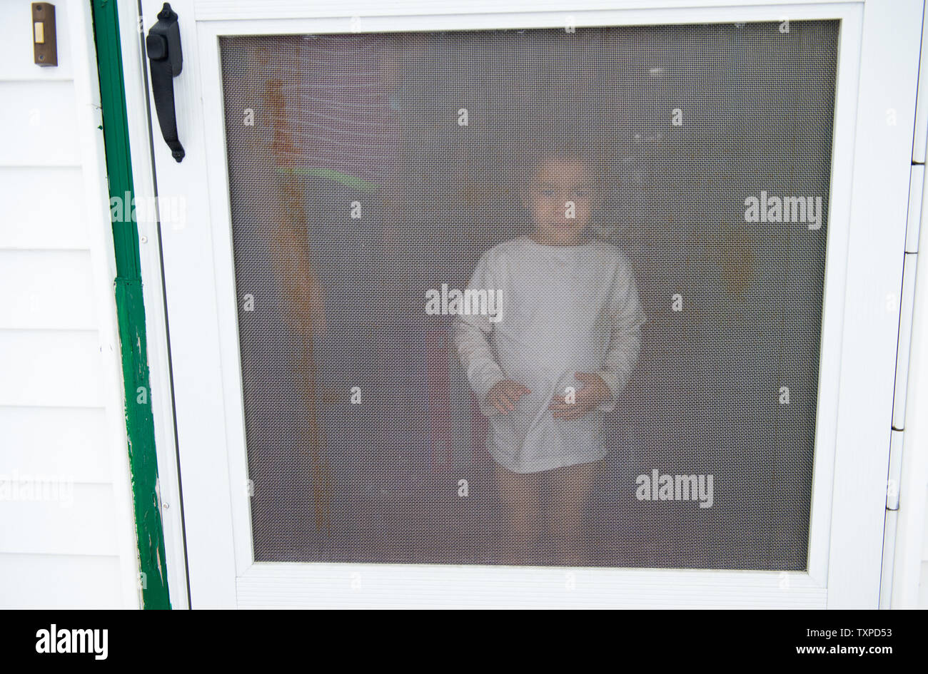 Flint Resident Isaiah 4 Years Old Peers Through His Screen Door