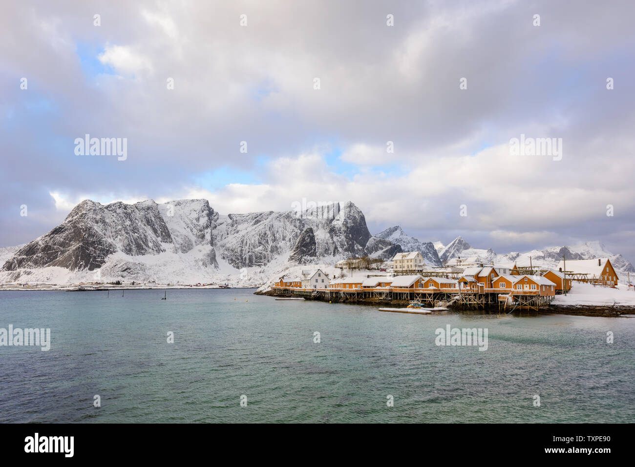 Typical Norwegian landscape. Beautiful view of scenic Lofoten Islands winter scenery with traditional yellow fisherman Rorbuer cabins in the historic Stock Photo