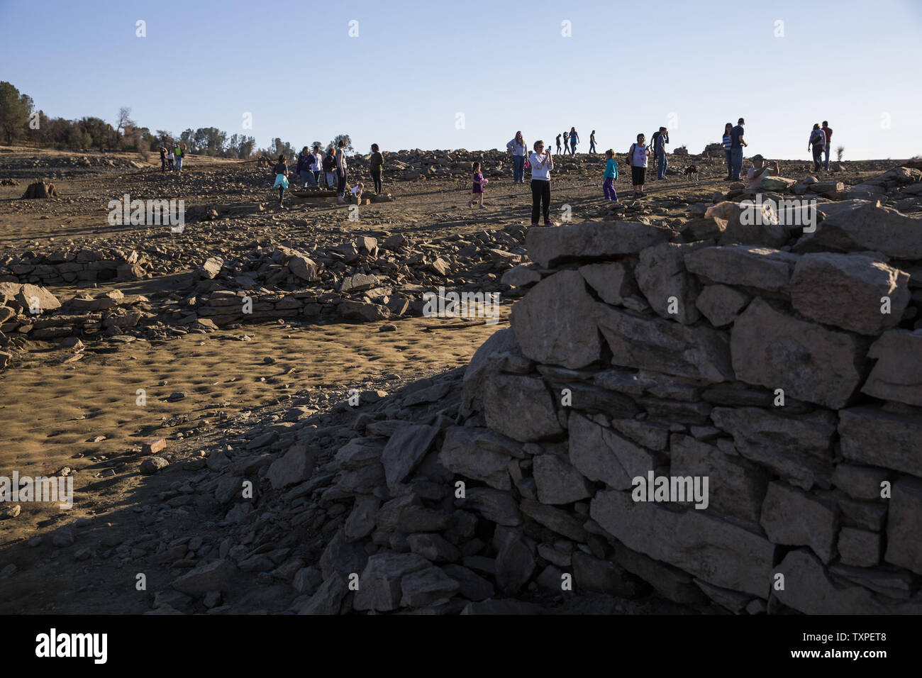 People look over remains of the old Gold Rush settlement of Mormon Island which has resurfaced due to the historic low water levels of Folsom Lake, in Folsom, California, on January 19, 2014. California Governor Jerry Brown declared a state wide drought last Friday. UPI/Ken James Stock Photo