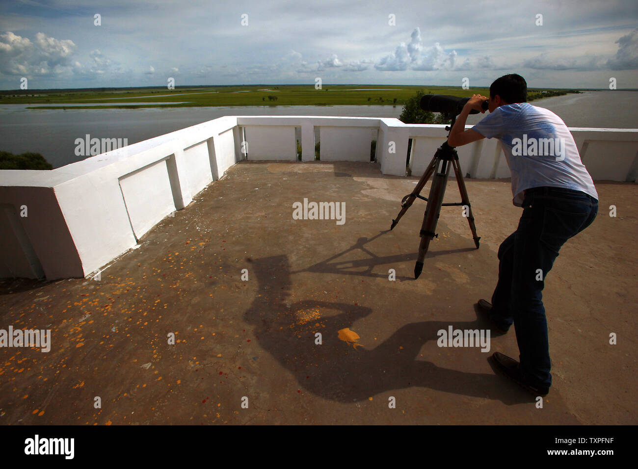 A Chinese tourist looks for wildlife in the massive Three Rivers Nature Reserve, the largest wetlands in China, in Fuyuan, a frontier town in China's northern Heilongjiang Province on August 4, 2013.  Ecotourism has been part of household vocabularies in China for a decade, however experts believe that the concept still has a long way to go in China.  Most domestic tourists are more interested in sightseeing than promoting environmental programs and awareness, according to a study.     UPI/Stephen Shaver Stock Photo
