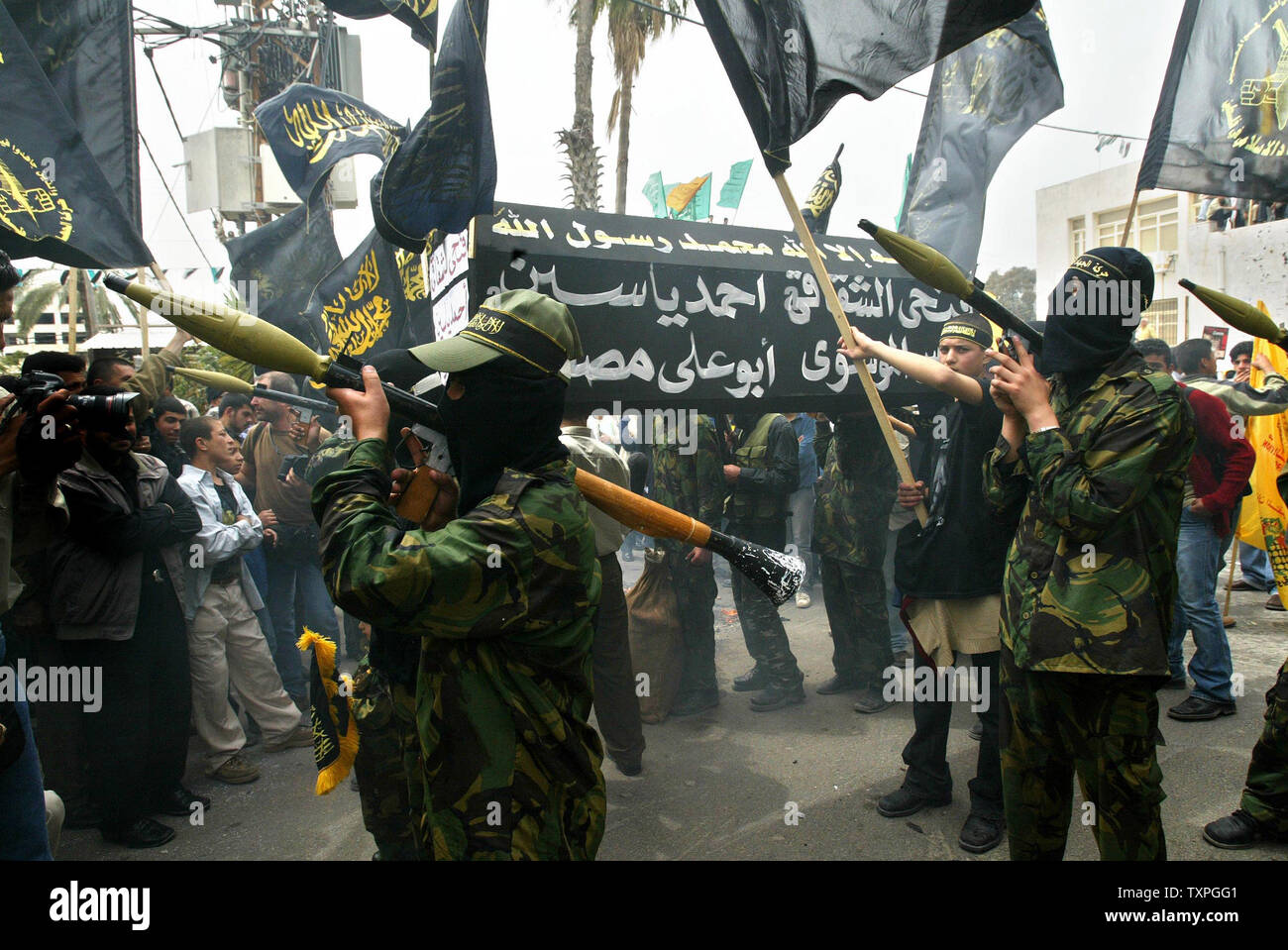 Masked Palestinian militants of the Islamic Jihad movement carry black  coffins and RPG launchers during a march through downtown Gaza City, on  March 30, 2004. Hundreds of Palestinian people, including Hamas, Fatah, image size:1300x959