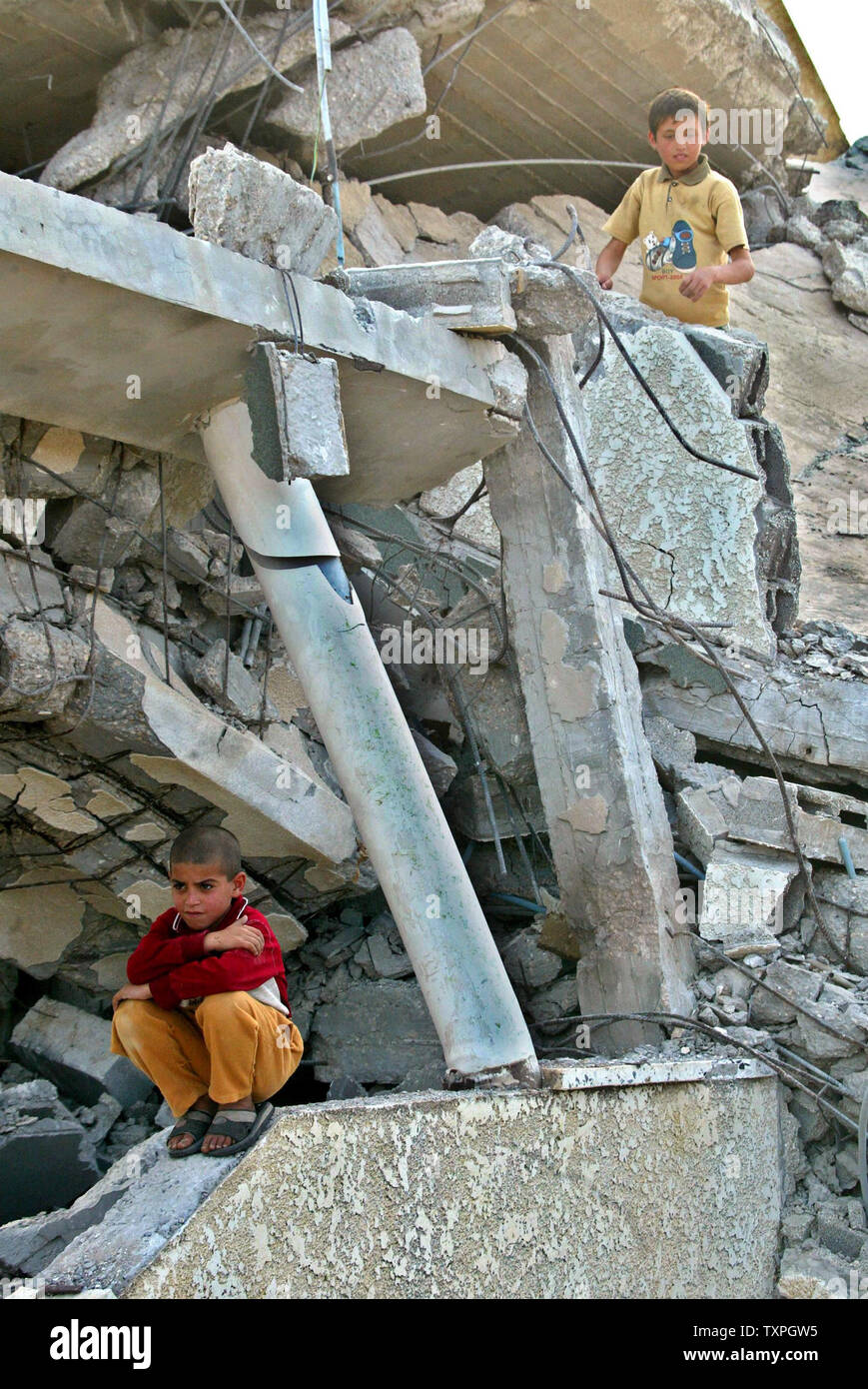 A Palestinian boy sits on the rubble of his home that was destroyed ...
