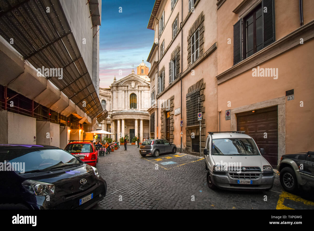 A Roman street with a sidewalk cafe in the Ponte District of Rome, Italy, and the Santa Maria della Pace, a small church near the Piazza  Navona Stock Photo