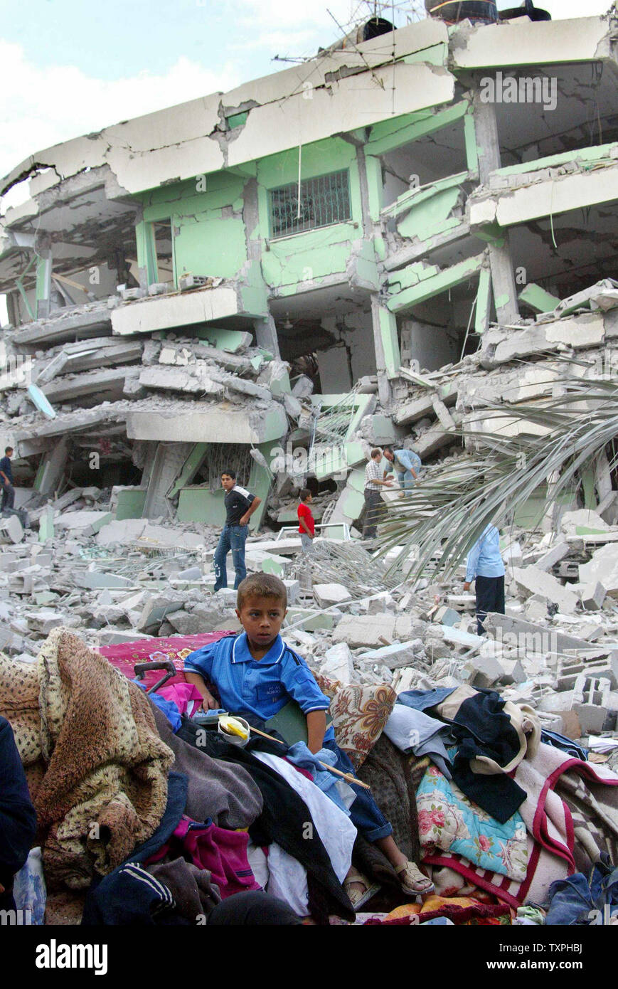A Palestinian boy sits on the rubble of his demolished house after an ...