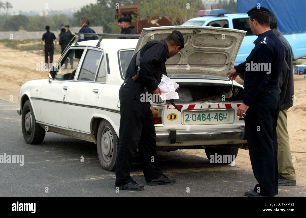 Palestinian police check a trunk during a search for stolen cars and