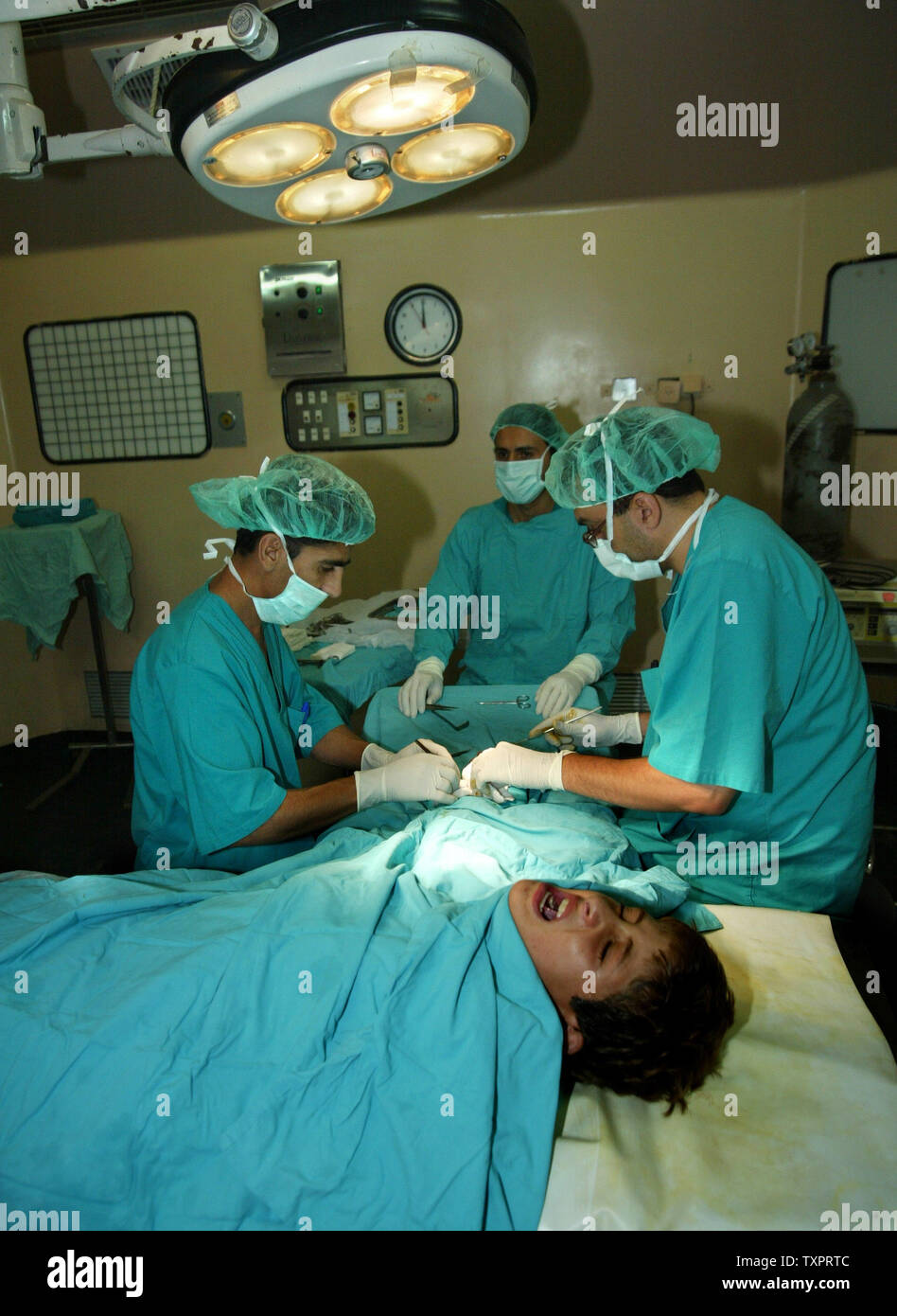 Palestinian doctors perform surgery on the hand of 13yearold Omar Hamada without the benefit