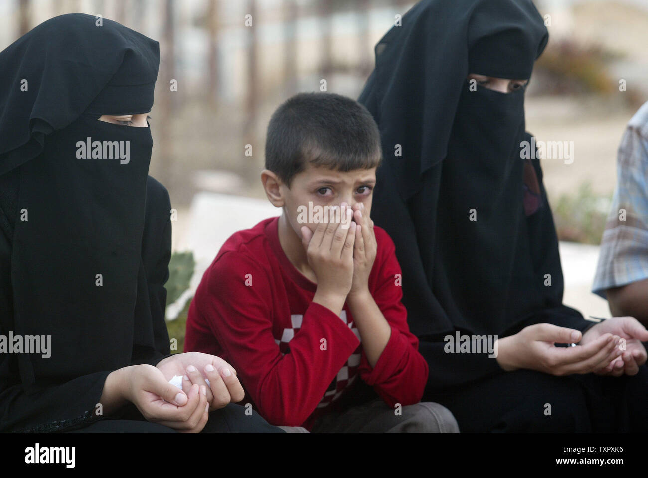 Palestinians visit the graves of their dead relatives and read from the ...