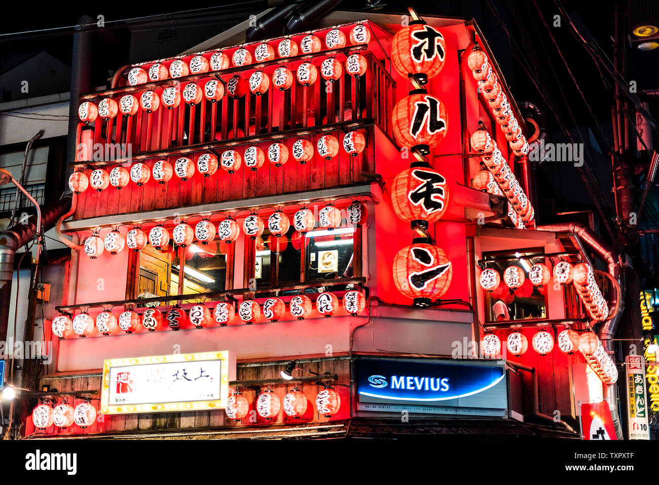 Osaka, Japan - April 13, 2019: Minami Namba famous street with dark night and illuminated neon buildings with many red paper lanterns Stock Photo