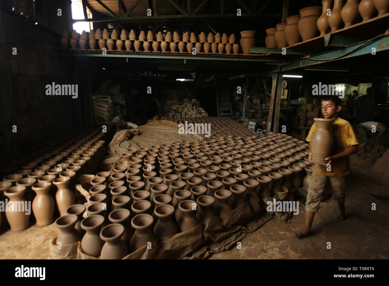 Palestinian pottery maker Nasr Atalah, aged 9, helps his father in his pottery factory in