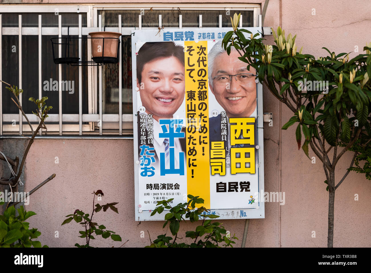 Kyoto, Japan - April 14, 2019: Election campaign sign on street by house building wall poster in Japanese and two candidates Stock Photo