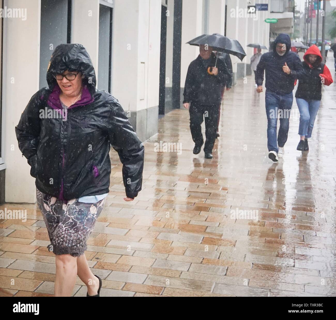 Sheffield, South Yorkshrie, UK. 25th June, 2019. A woman runs for cover out of the downpour at the Moor Market Credit: Ioannis Alexopoulos/Alamy Live News Stock Photo