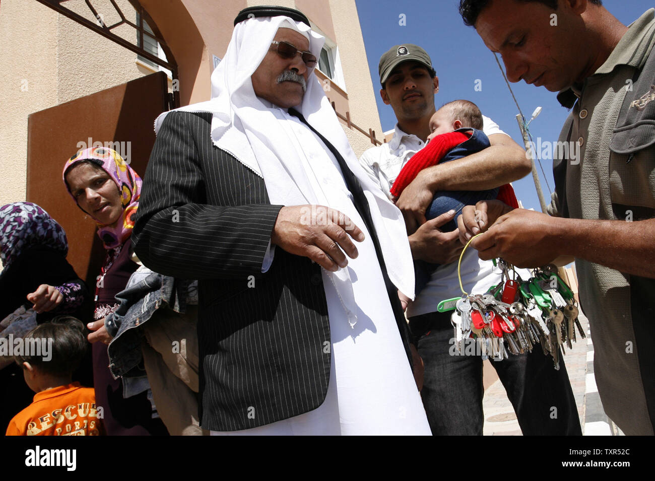 A Palestinian man receives a key to his new house during a ceremony inaugurating a housing project in Khan Younis in the southern Gaza Strip on April 24, 2012.  The United Nations Relief and Work Agency (UNRWA), funded by a $7.2 million donation from the Netherlands, announced the housing project to shelter 1,300 homeless Palestinians. UPI/Ismael Mohamad Stock Photo