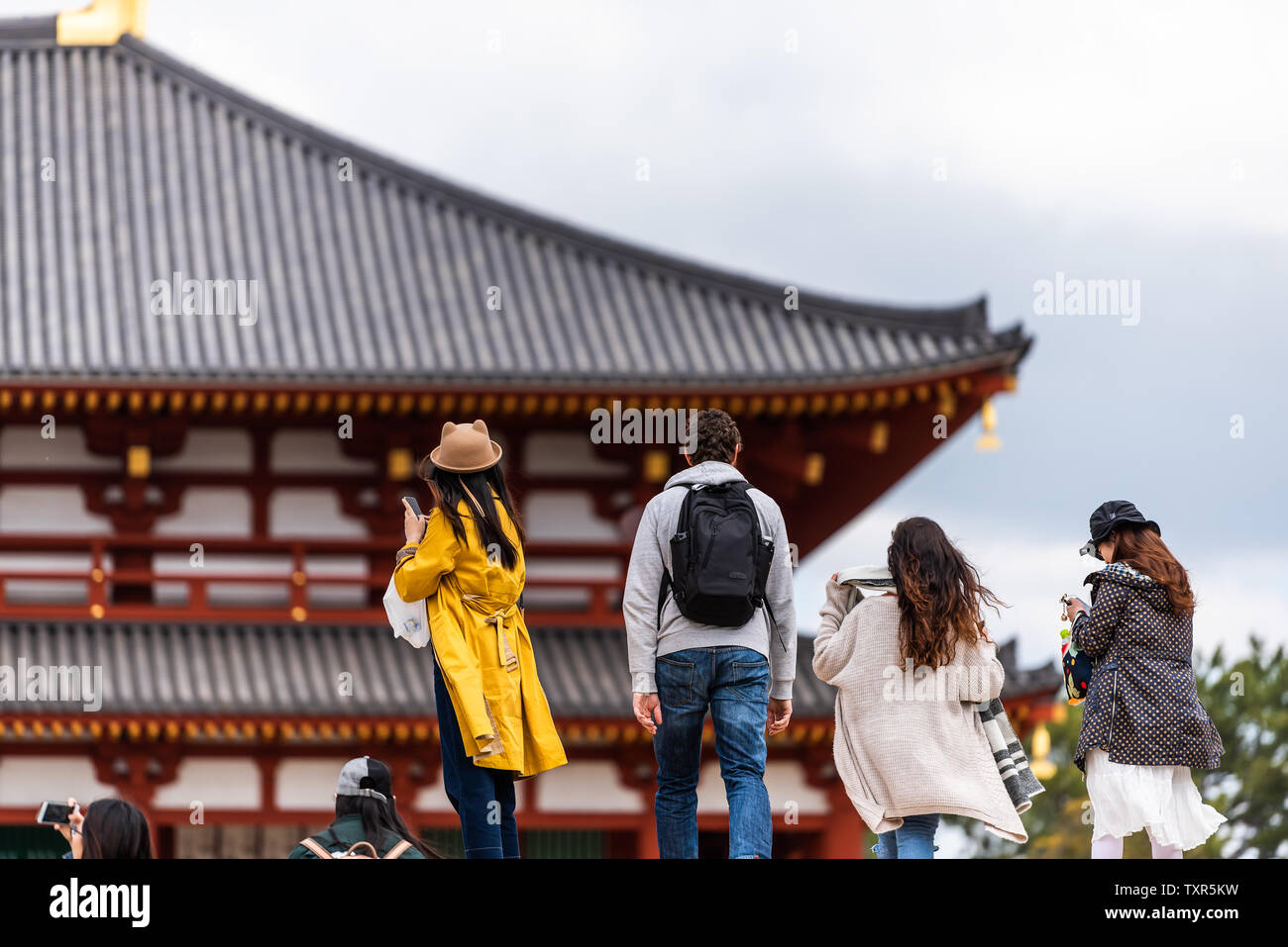 Nara, Japan - April 14, 2019: Back of people looking taking pictures of Kofuku-ji temple Chu-Kondo Central Golden Hall in city Stock Photo