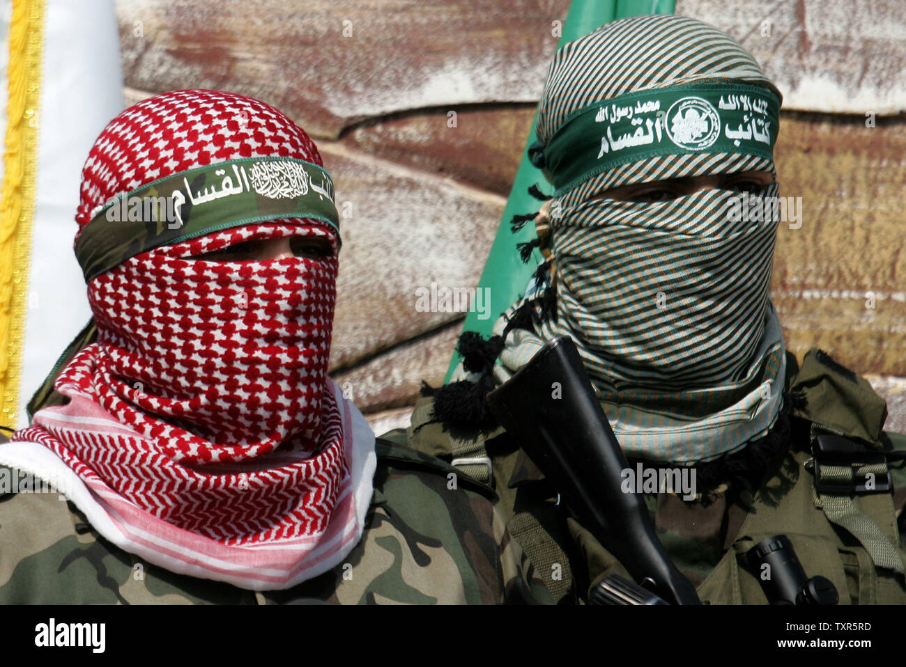 Abu Obaida (L), the spokesman for the Ezzedine Al-Qassam Brigades, the armed wing of Hamas, speaks during a news conference on October 18, 2012 at the Rafah border crossing with Egypt in the southern Gaza Strip to mark the first anniversary of a deal which saw the exchange of 1,027 Palestinian prisoners for captured Israeli soldier Gilad Shalit. The snatching of Israeli soldier Gilad Shalit in June 2006 by a group of Hamas militants and others sparked a more than five-year crisis for Israel, which finally ended on October 18, 2011. UPI/Ismael Mohamad Stock Photo
