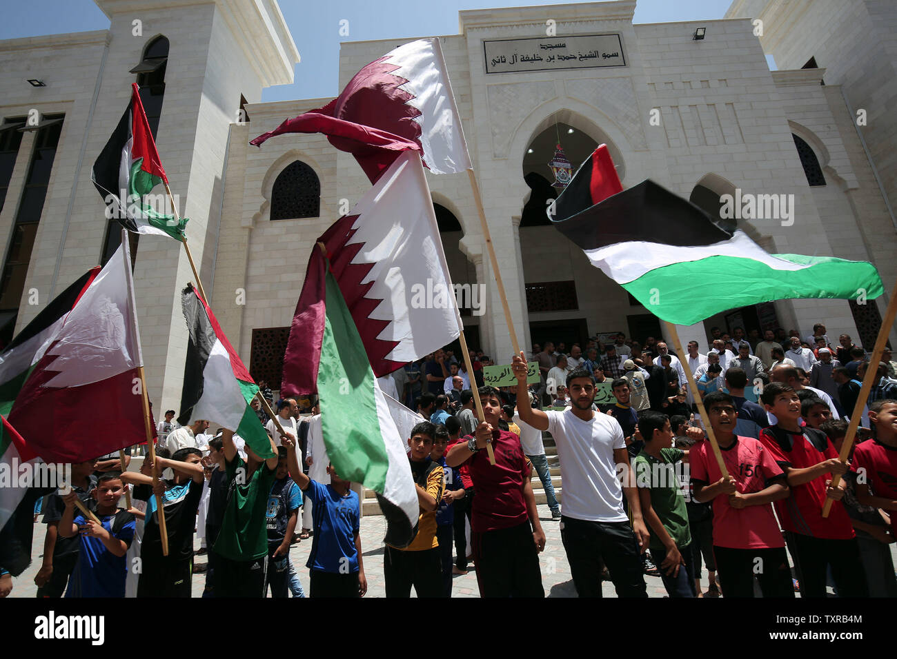 Palestinians Holds A Qatari Flags During A Rally In Support Of