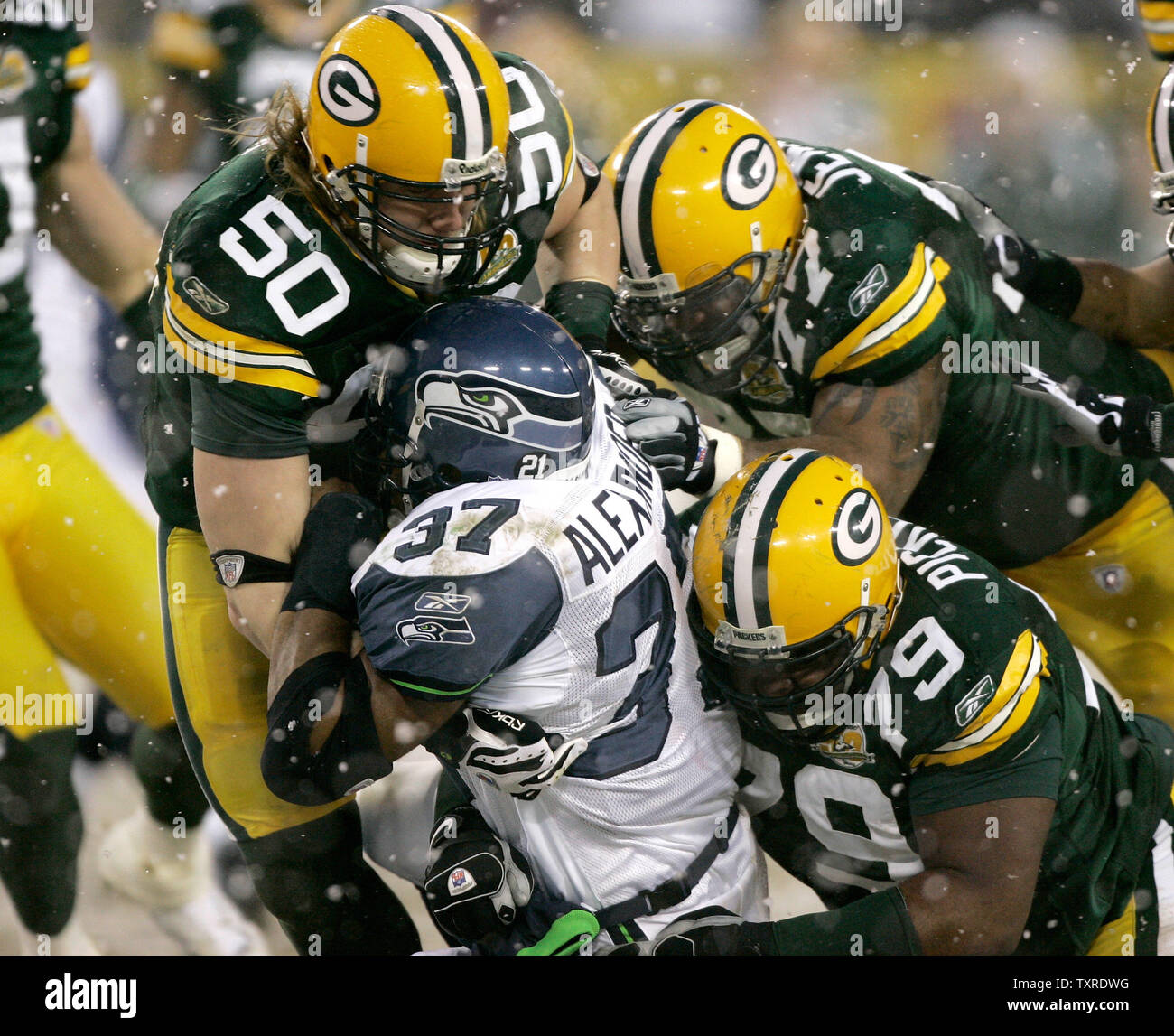 Green Bay Packers' linebacker A. J. Hawk (50), and defensive linemen Cullen  Jenkins (77) and Ryan Pickett (79) stop Seattle Seahawks running back Shaun  Alexander (37) for a loss during the first