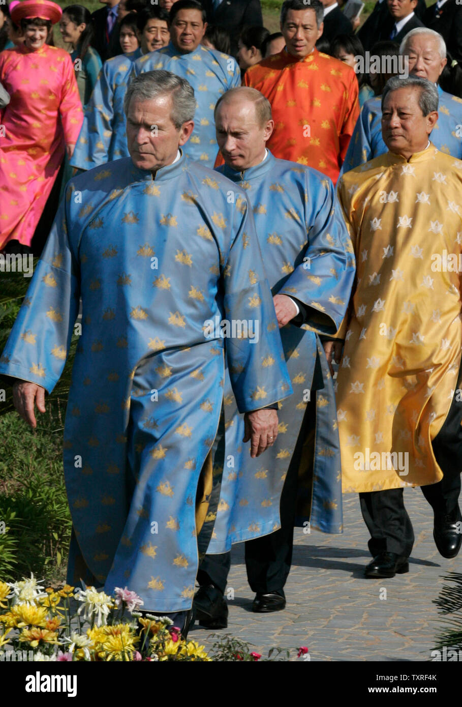 us-president-george-w-bush-l-and-russian-president-vladimir-putin-c-wearing-vietnamese-ao-dai-silk-tunics-walk-out-for-the-official-photograph-at-the-asia-pacific-economic-cooperation-apec-summit-in-hanoi-on-november-19-2006-upi-photoanatoli-zhdanov-TXRF4K.jpg