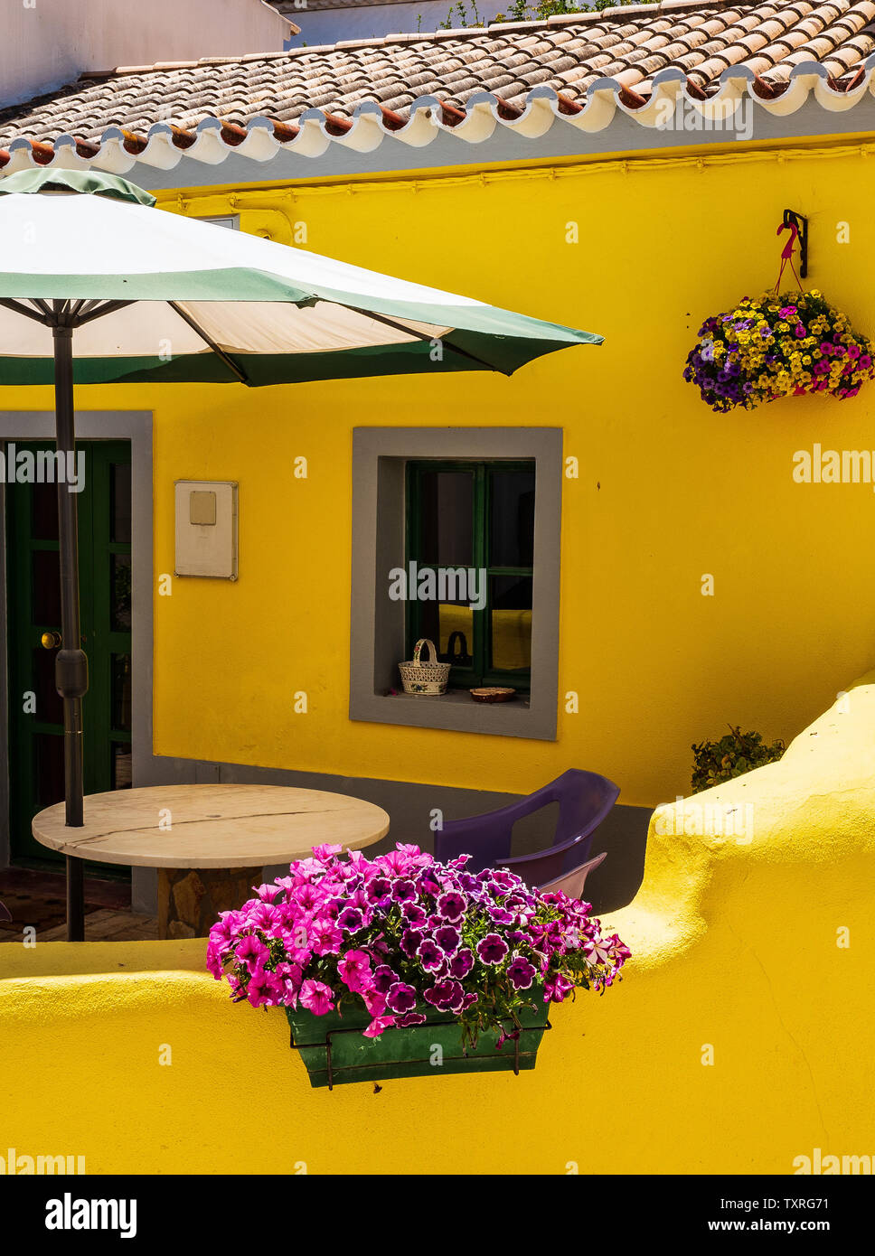 Stunning yellow house, purple flowers, Burgau Village Stock Photo