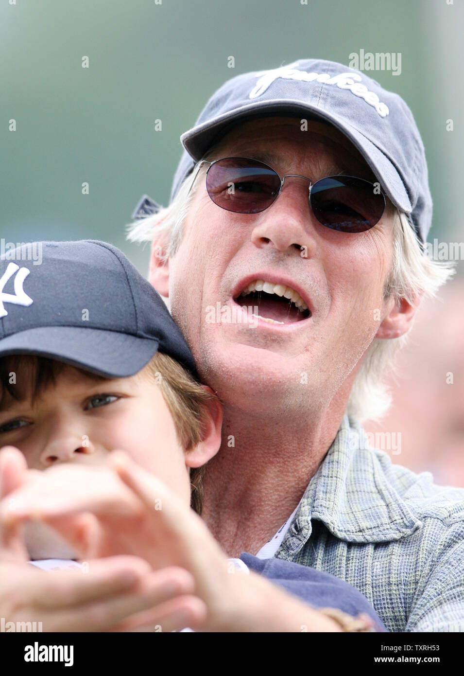 Actor Richard Gere holds son Homer as he claps for friend Cal Ripken Jr., during induction ceremonies at the National Baseball Hall of Fame in Cooperstown, New York on July 29, 2007.  (UPI Photo/Bill Greenblatt) Stock Photo