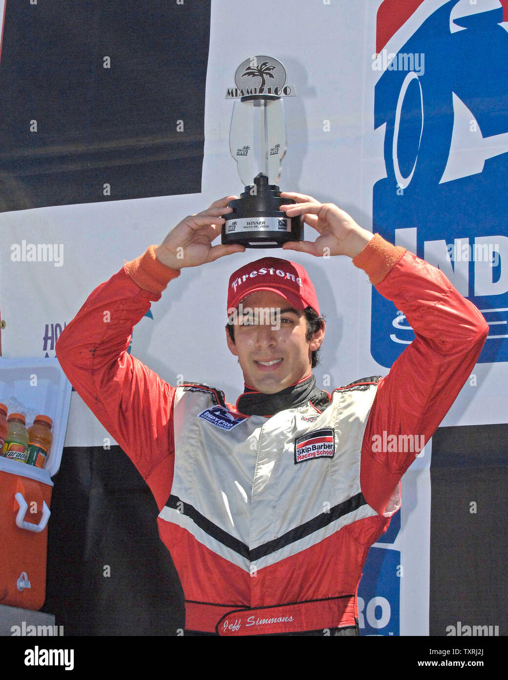 Race car driver, Rick Simmons raises his trophy after winning the Indy