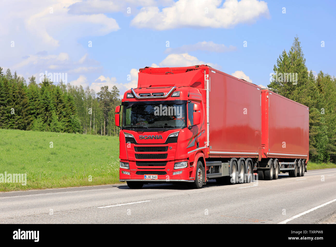 Jyvaskyla, Finland. June 8, 2019. New red Scania R650 truck with full trailer of Konnekuljetus Oy hauls goods along highway on a sunny day of summer. Stock Photo