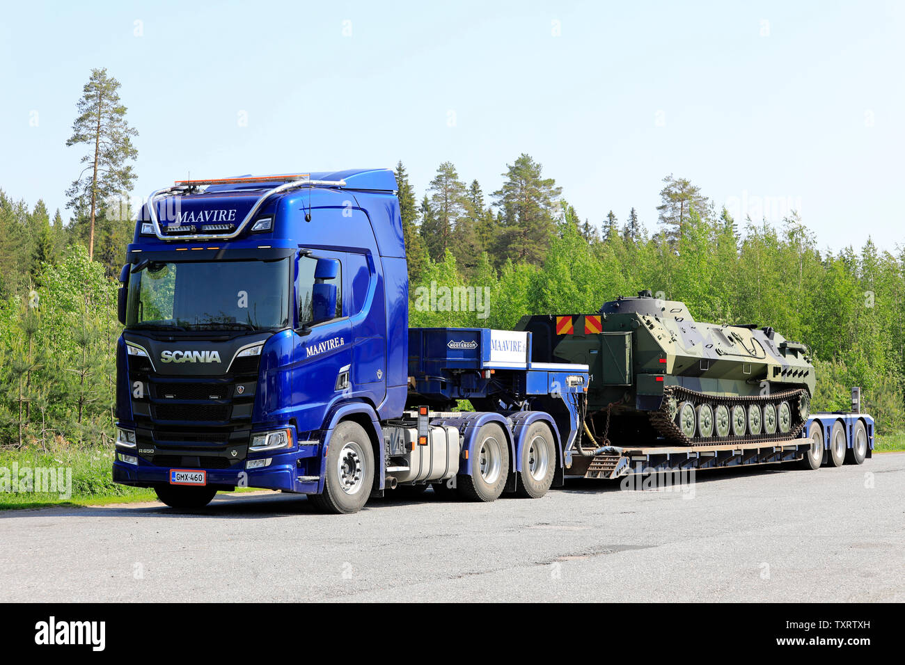 Orivesi, Finland. June 6, 2019. New blue Scania R650 truck of Maavire with battle tank on flat bed trailer on truck stop yard on sunny day of summer. Stock Photo
