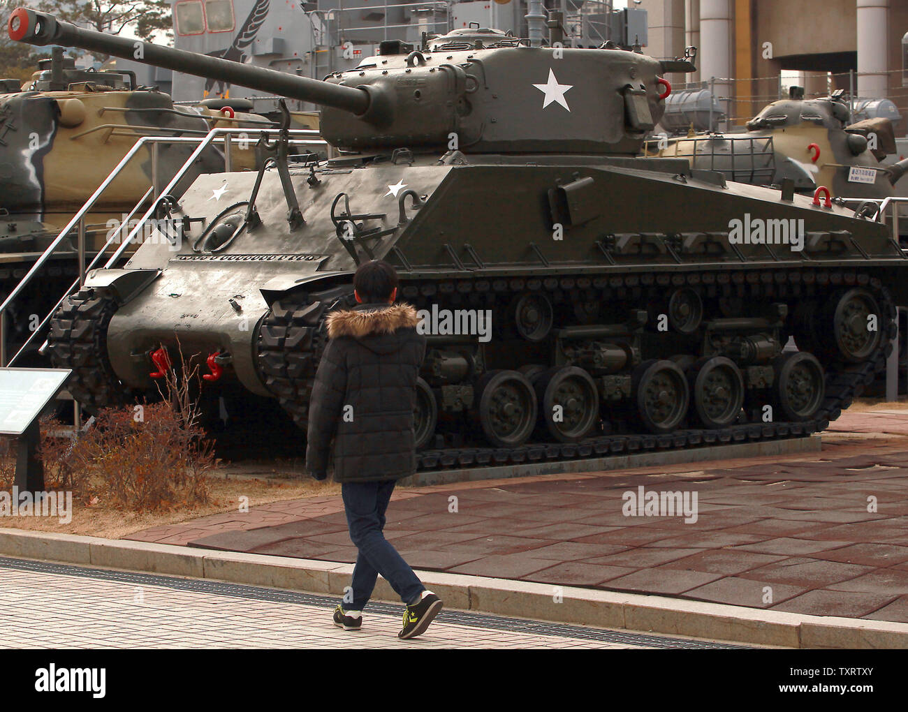 A South Korean walks by a Sherman tank on display at the War Memorial of Korea in Seoul on January 28, 2013. North Korea said last week that it plans to carry out a new nuclear test and more long-range rocket launches, all of which it said are part of a new phase of confrontation with the United States. North Korea also warned of the possibility of "strong physical counter-measures" against South Korea if they support tougher UN sanctions. UPI/Stephen Shaver Stock Photo