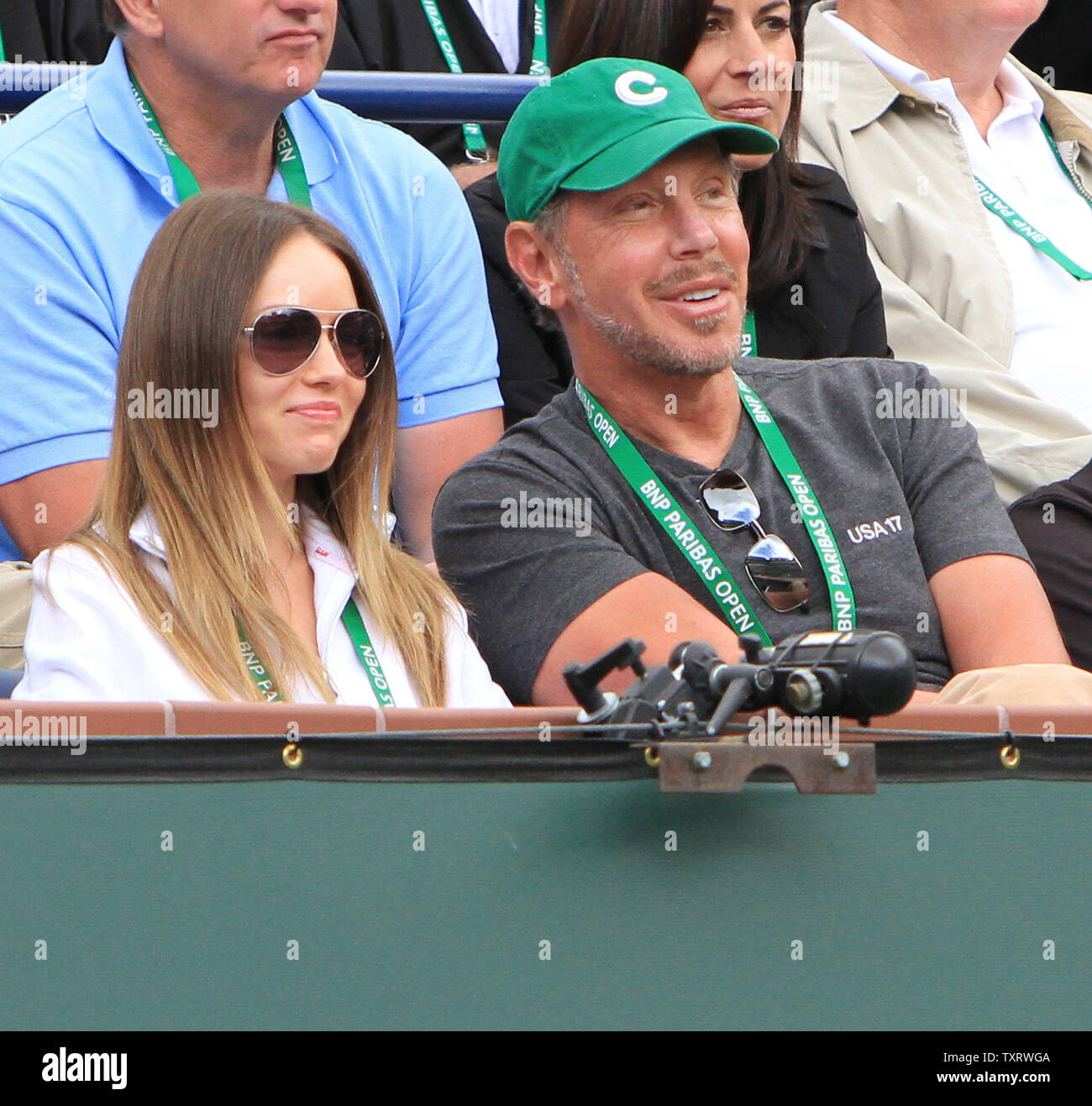 Oracle CEO and tournament owner Larry Ellison and guest watch the mens semifinal match between American John Isner and Serbian Novak Djokovic at the BNP Paribas Open in Indian Wells, California on