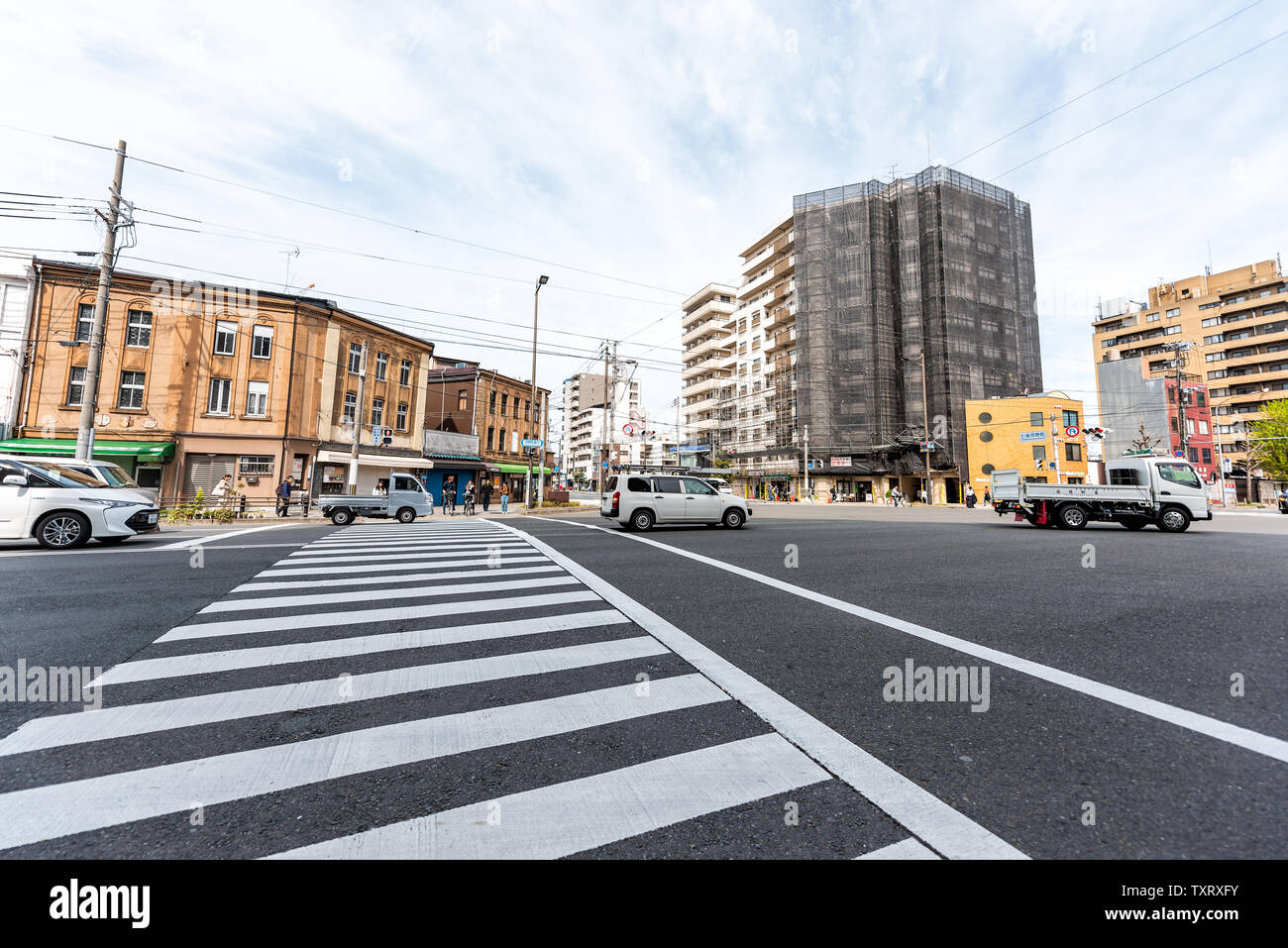 Kyoto, Japan - April 17, 2019: City street crossing wide angle view during sunny day morning near station with traffic Stock Photo