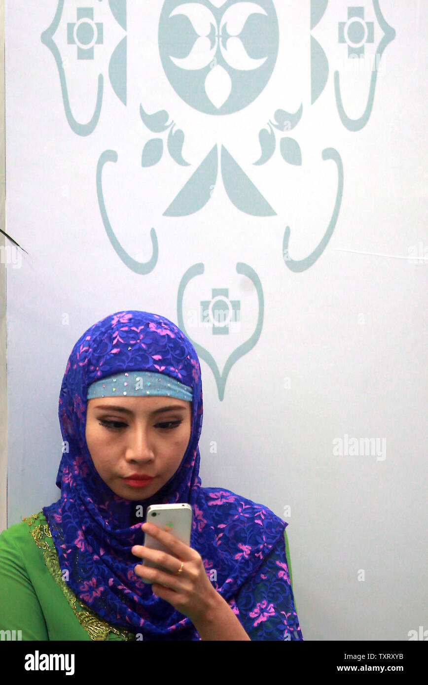 A Chinese Muslim woman uses her smartphone during the opening of the China-Arab State Expo beijing held in Yinchuan, the capital of China's northwestern Ningxia Hui Autonomous Region on September 15, 2013.  Yinchuan, a predominantly Muslim city and a major crossroad between China and her Muslim neighbors, is being developed as the capital of China-Arab bilateral trade.    UPI/Stephen Shaver Stock Photo