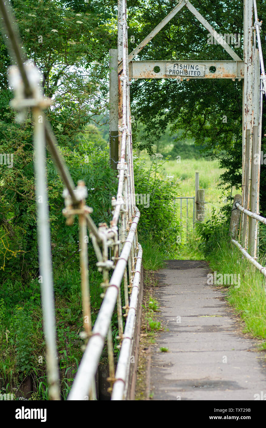 Small suspension bridge with Fishing Prohibited sign on the Avon Valley footpath, Hampshire Stock Photo