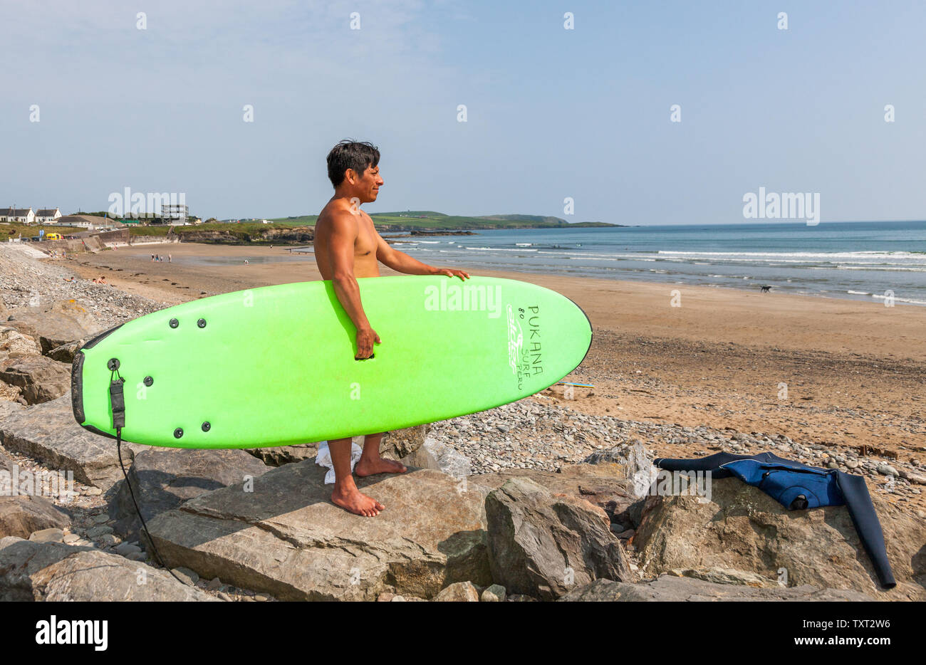 Garrettstown, Cork, Ireland. 25th June, 2019. As the summer temperature begins to rise, Carlos Amaya from Crosshaven views the sea conditions before going surfing at Garrettstown, Co. Cork, Ireland. Credit: David Creedon/Alamy Live News Stock Photo
