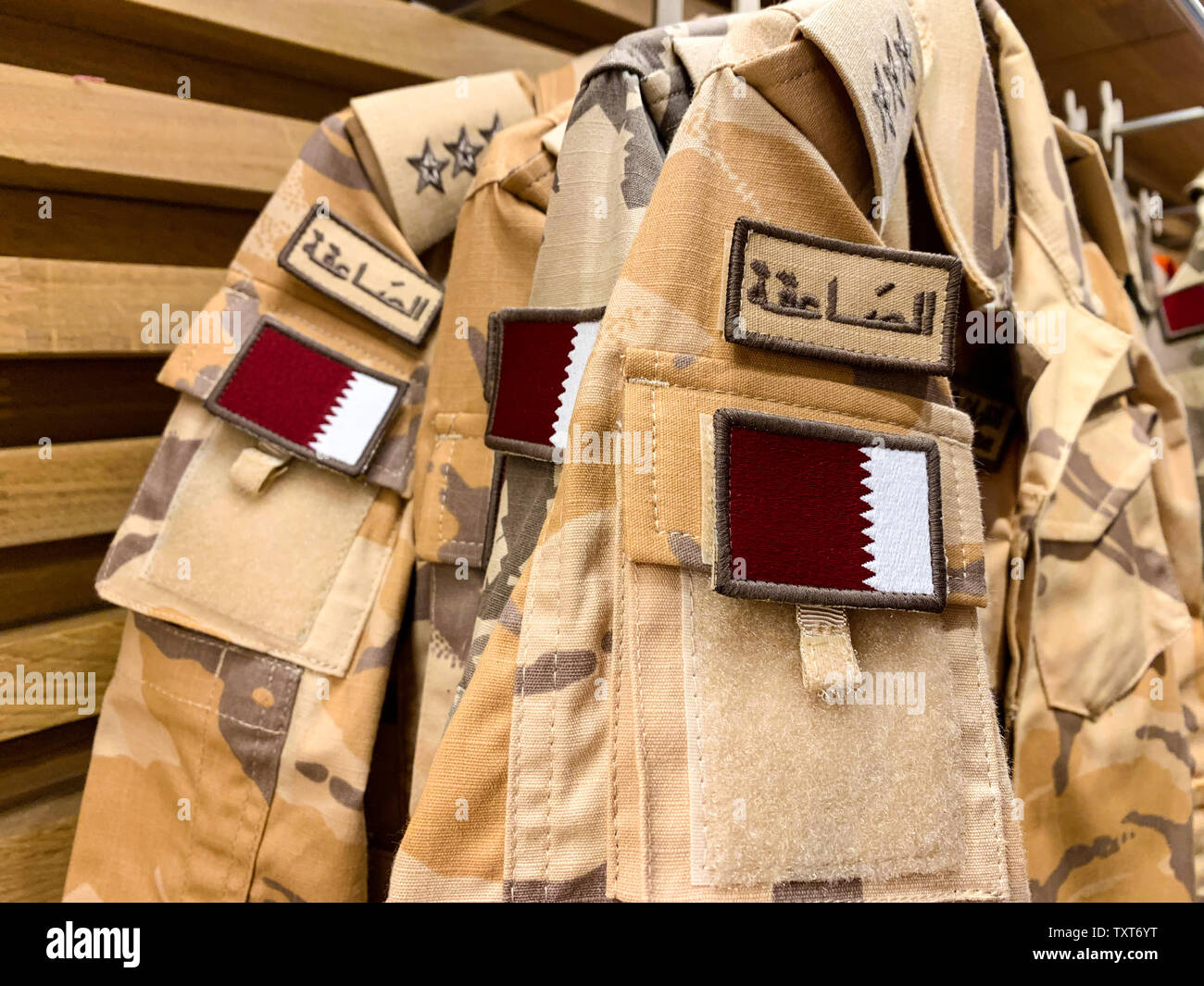 Military pattern workwear with the Qatari flag hanging in a row. April 2019, Doha/ Qatar. Stock Photo