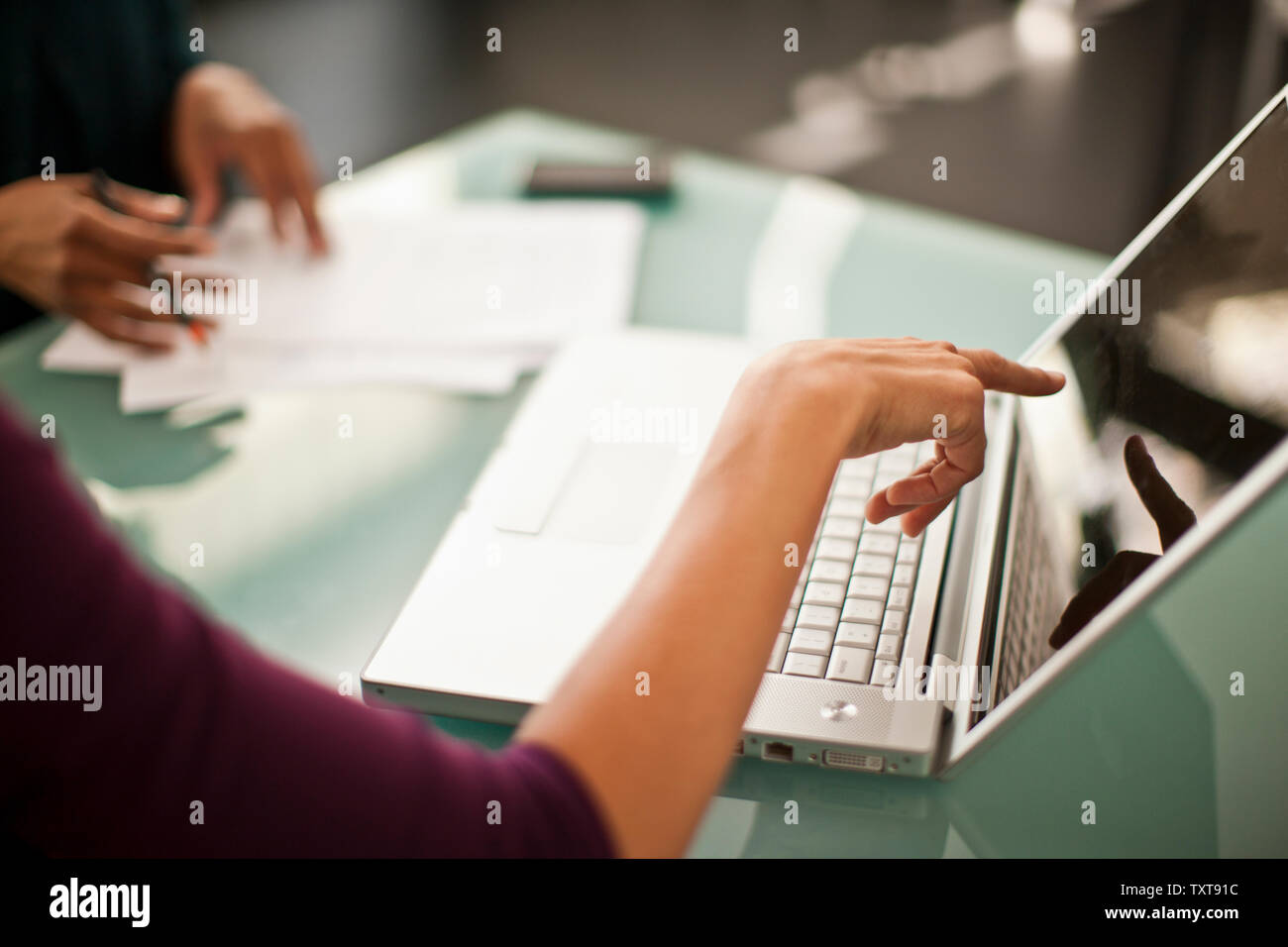 Two colleagues working together on a laptop computer. Stock Photo