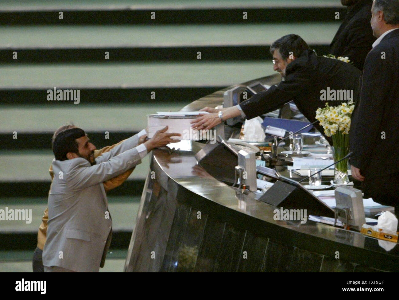 Iran's president Mahmoud Ahmadinejad (L) delivers budget bill to parliament speaker Gholamali Haddad Adel in parliament in Tehran, Iran on January 15, 2006. Iranian President Mahmoud Ahmadinejad said his nation has no intention of building nuclear weapons amid rising international concern that the Islamic nation's uranium enrichment research is a front for developing atomic bombs.(UPI Photo/Mohammad Kheirkhah) Stock Photo