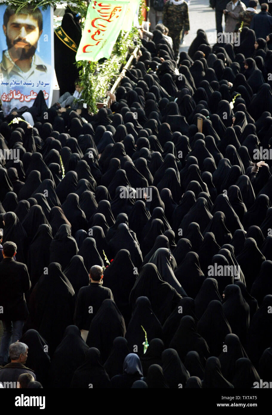 Iranian women follow a truck carrying the dead during a funeral ceremony for 110 people that were killed during the 8-year Iran-Iraq war, whose bodies were finally recovered after 17 years, in Tehran, Iran, on November 25, 2005.   (UPI Photo/Mohammad Kheirkhah) Stock Photo