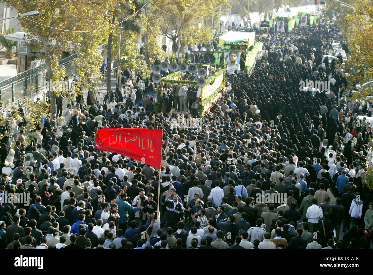 Iranians follow a truck carrying the dead during a funeral ceremony for 110 people that were killed during the 8-year Iran-Iraq war, whose bodies were finally recovered after 17 years, in Tehran, Iran, on November 25, 2005.   (UPI Photo/Mohammad Kheirkhah) Stock Photo