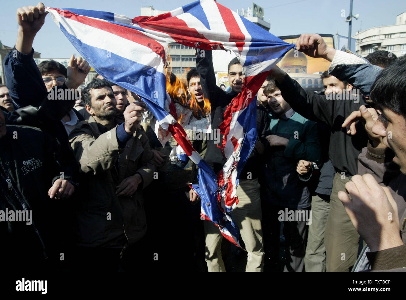 Iranians burn a British flag while protesting after weekly Friday prayer at Tehran University in Tehran, Iran on February 24, 2006.  The protest is over the destruction of a Shiite shrine in Samarra, Iraq by bomb. (UPI Photo/Mohammad Kheirkhah) Stock Photo