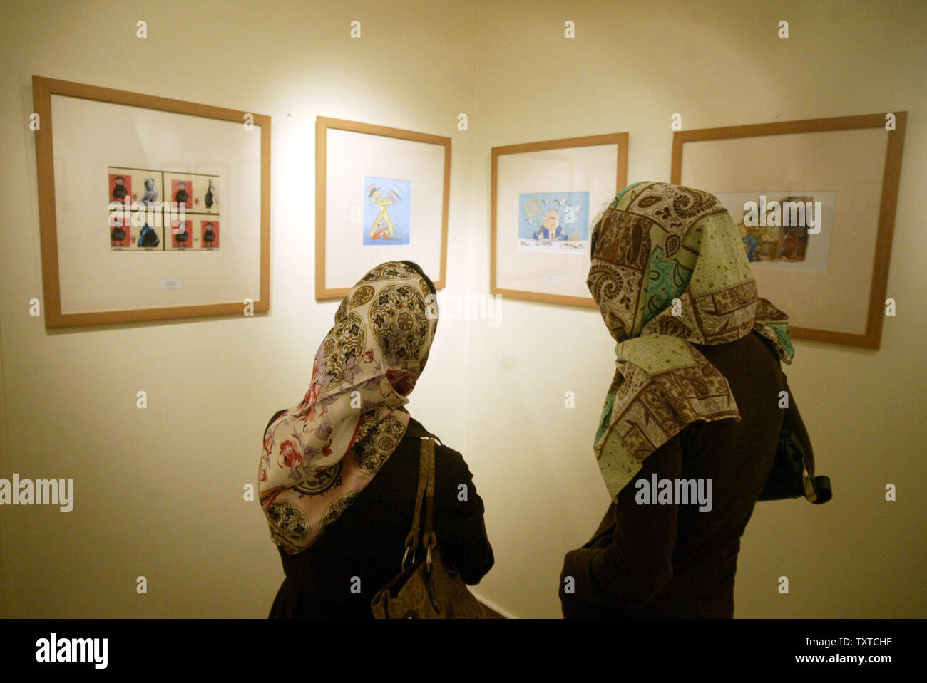 Two Iranian woman visit the Holocaust International Cartoon contest exhibition in Tehran, Iran on August 14, 2006. The contest is sponsored by Tehran's Hamshahri Newspaper and is aimed at testing how committed Europeans were to the concept freedom of expression. This contest comes months after a Danish paper published satirical cartoons of the Islamic Prophet Muhammad. (UPI Photo/Mohammad Kheirkhah) Stock Photo