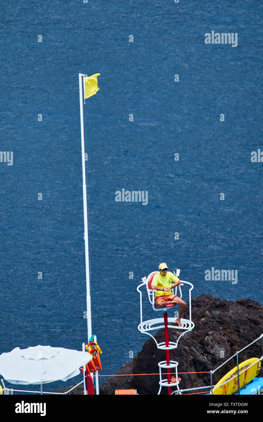 Lifeguard in yellow top along the Frente Mar area of Funchal, madeira, Portugal Stock Photo