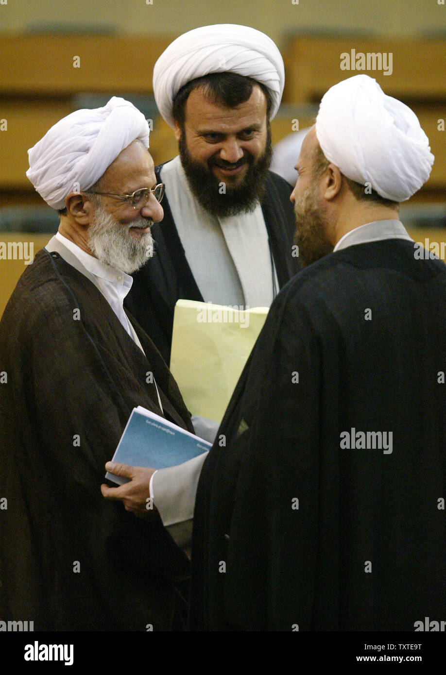 Iran's top cleric Mohammad Taqi Mesbah Yazdi (L) speaks with two unknown clerymen during the inauguration ceremony of the 4th International General Assembly session of The Ahlul-Bayt World Assembly at Tehran Summit Hall in Tehran, Iran on August 18, 2007. Tehran has declared illegal the alleged intention by the US government to label the Iranian Revolutionary Guard as a foreign terrorist organization. (UPI Photo/Mohammad Kheirkhah) Stock Photo