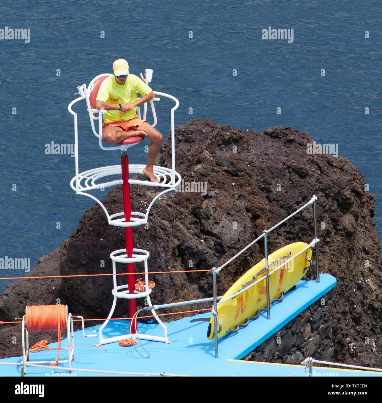 Lifeguard in yellow top along the Frente Mar area of Funchal, madeira, Portugal Stock Photo