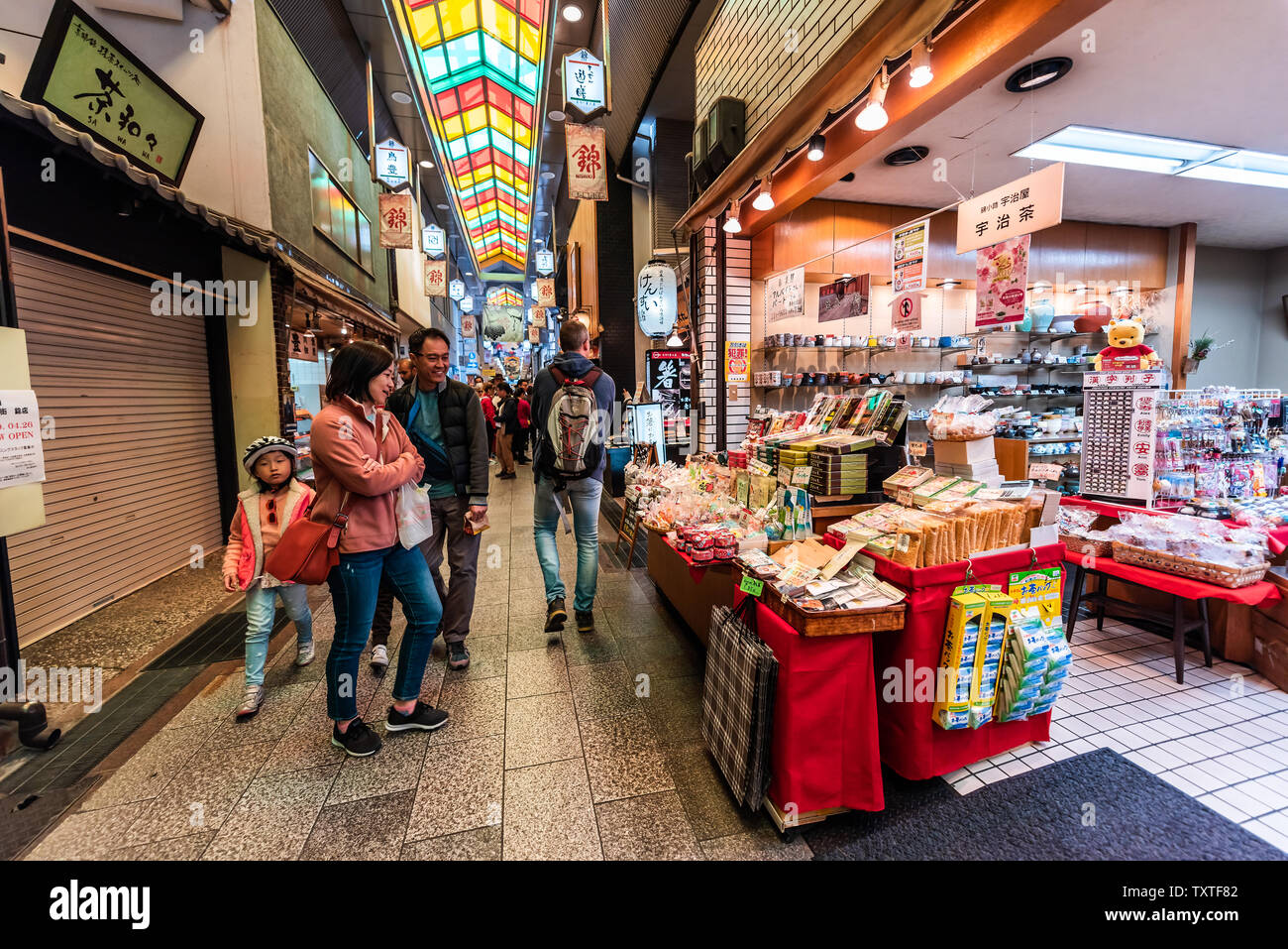Nishiki Market covered shopping arcade in Kyoto with traditional storefronts and kimono-clad visitors, perfect for rainy day exploration and authentic Japanese cultural photography