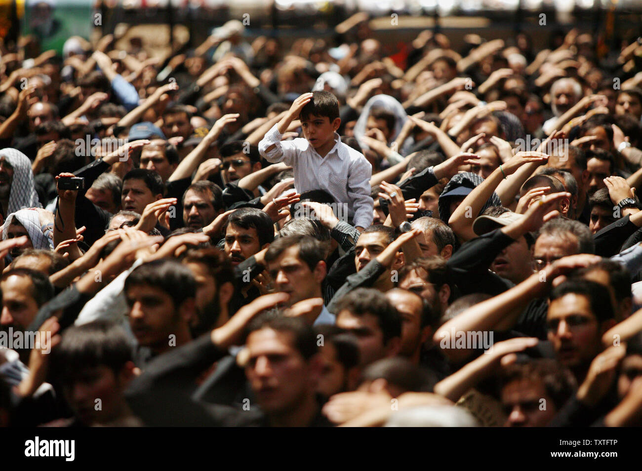 An Iranian boy with other men beat their heads to mourn the death of