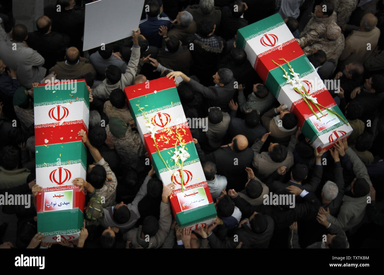 Iranians carry the flag draped coffins containing the remains of a  Revolutionary Guard soldiers  who were killed in explosion in Bidegeneh village, about 35 Kilometers (21 miles) west of Tehran. The explosion happened on Saturday when  a munitions depot caught fire at the IRGC base in Bidgeneh village. The Total of 17 IRGC forces, including Maj. Gen. Hassan Tehrani Moqaddam, director of the Guard's Jihad Self-Sufficiency Organization were killed and 16 others were seriously injured. Tehran, Iran , November 14, 2011.     UPI/Maryam Rahmanian. Stock Photo
