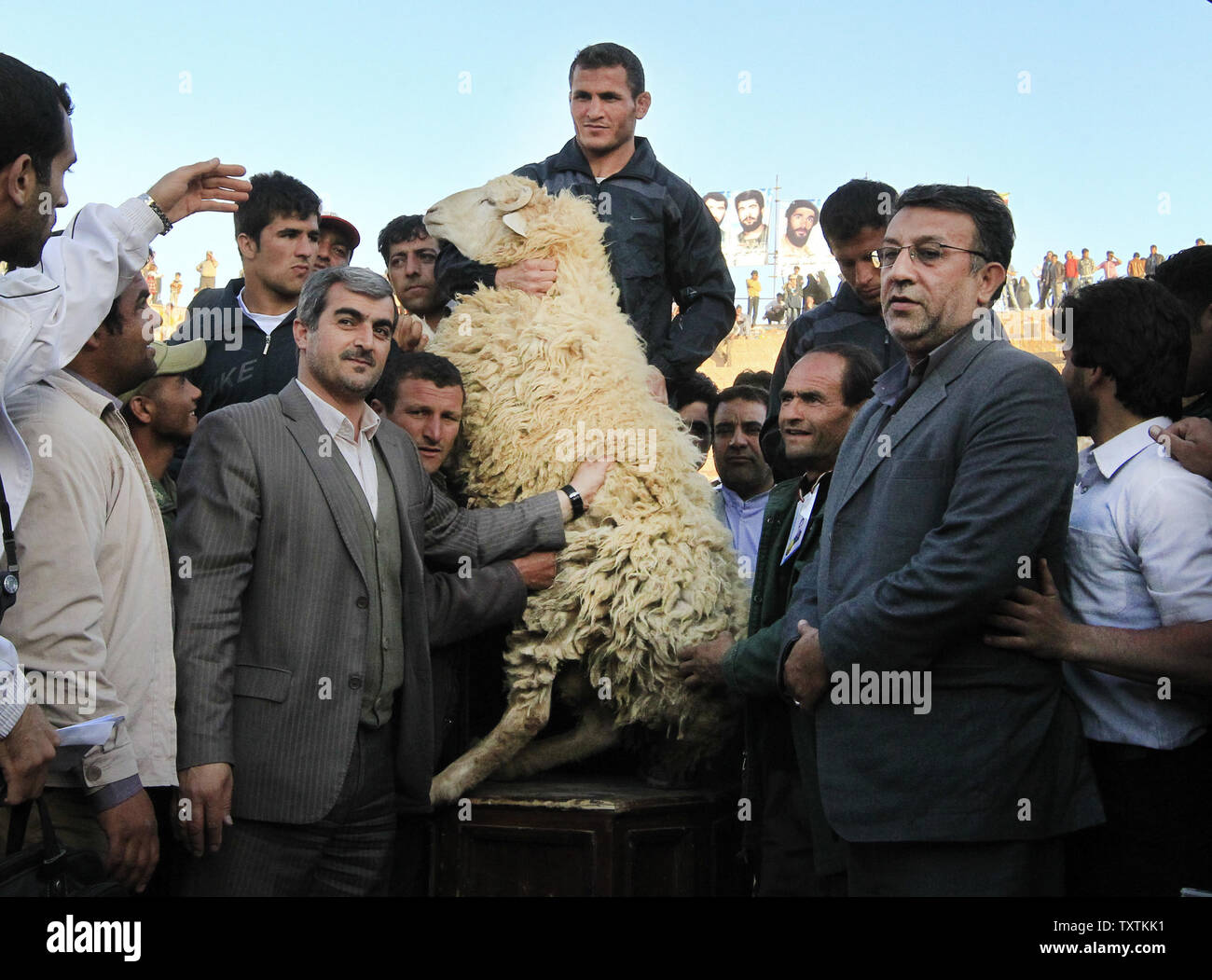 a-wrestler-holds-a-sheep-as-a-prize-after-winning-in-a-traditional-wrestling-tournament-called-bachokheh-in-esfarayen-iran-on-april-2-2012-bachokheh-traditionally-played-on-the-13th-and-14th-of-the-iranian-new-year-has-gained-popularity-in-recent-years-upimaryam-rahmanian-TXTKK1.jpg